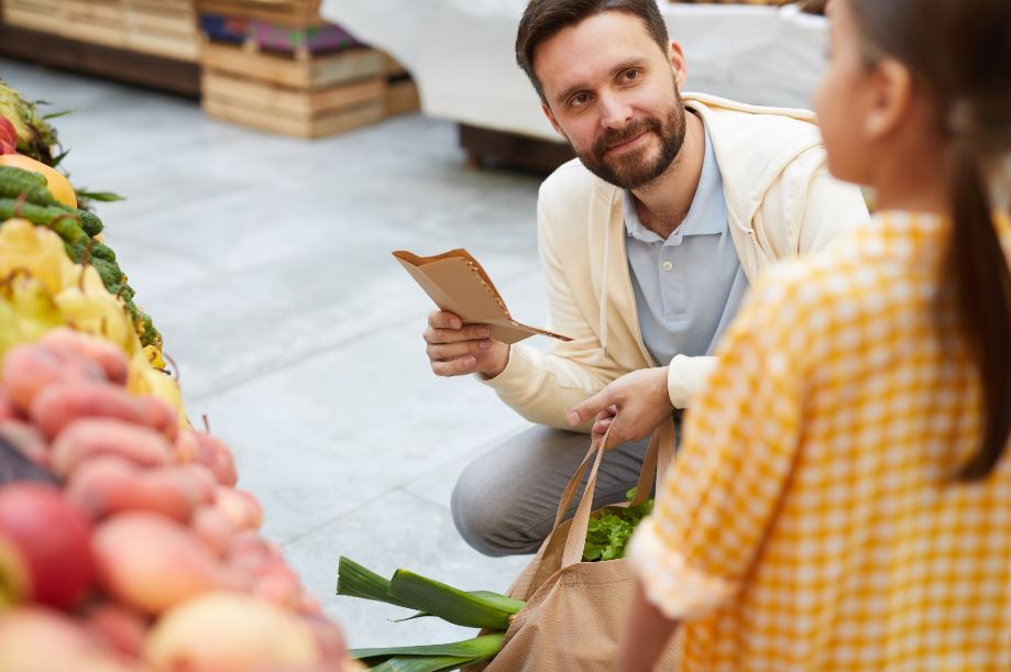father and daughter at a Los Angeles farmers market with a list