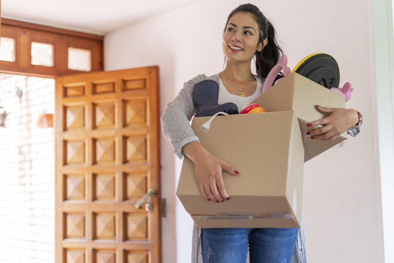 Woman carrying boxes as she starts moving back home
